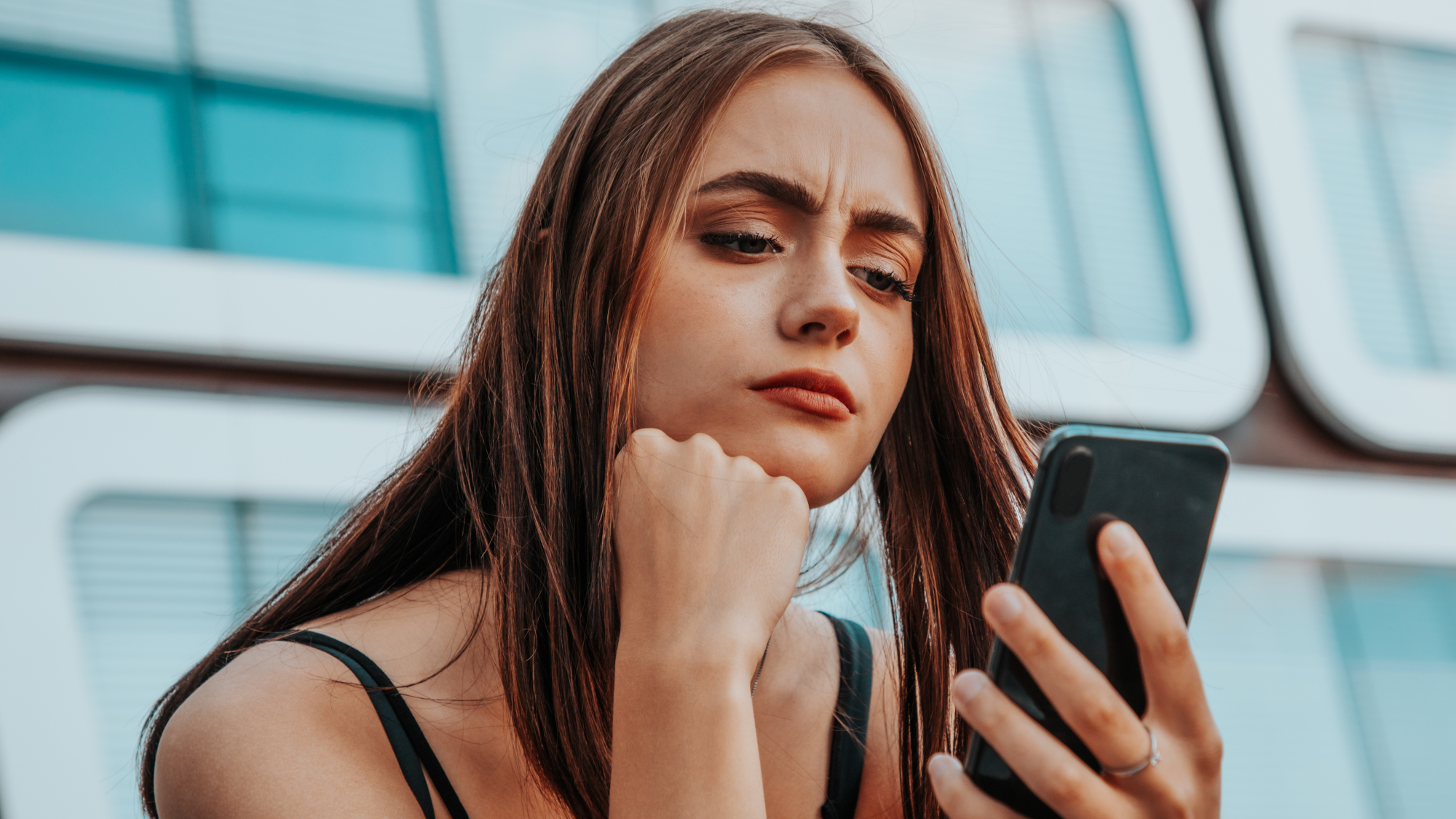 Teenager looking perplexed at their smartphone