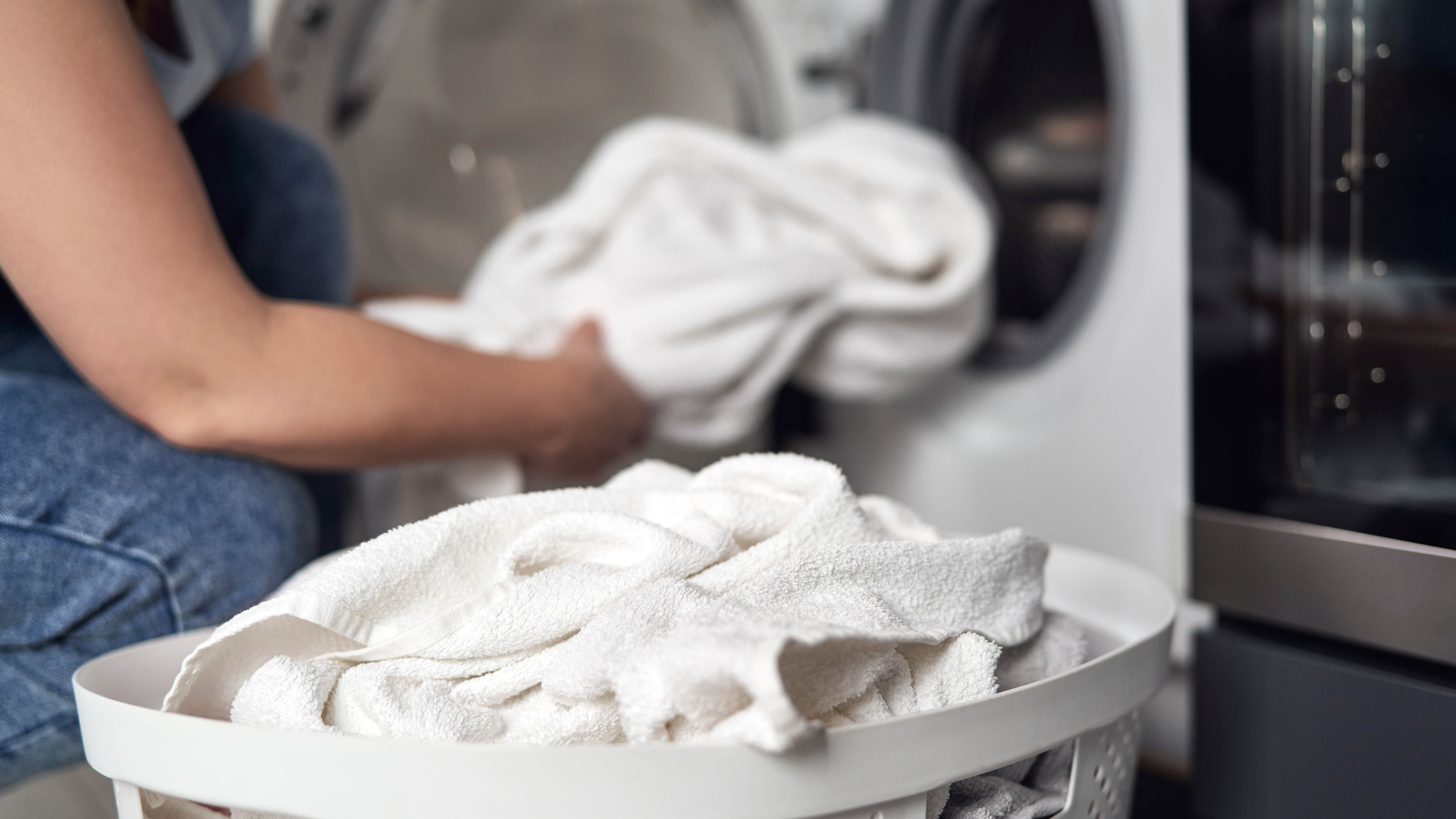 Loading white towels into washing machine