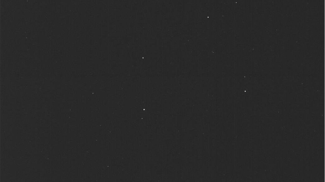 a nearly all black image, with a half dozen faint points of light scattered about