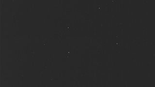 a nearly all black image, with a half dozen faint points of light scattered about