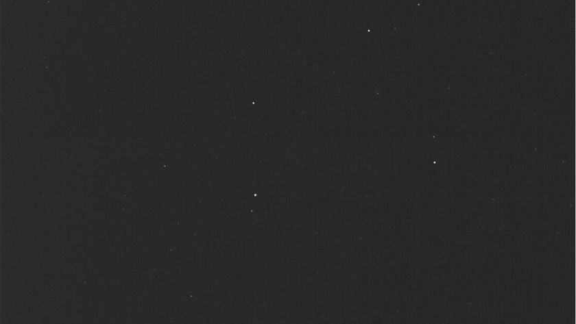 a nearly all black image, with a half dozen faint points of light scattered about