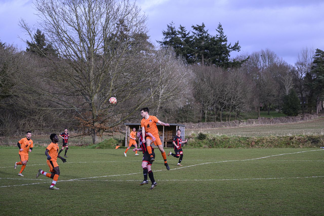 Some footballers playing in a field