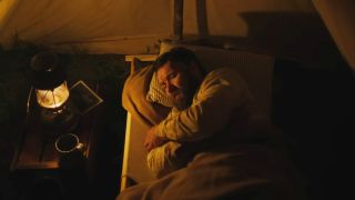 Joel Edgerton lying in bed in Train Dreams.