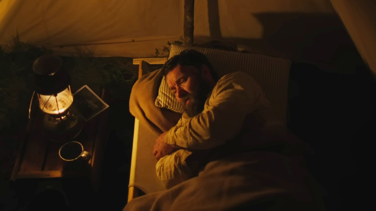 Joel Edgerton lying in bed in Train Dreams.