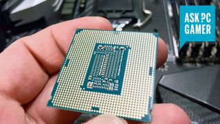 Intel CPU held in hand with contacts showing