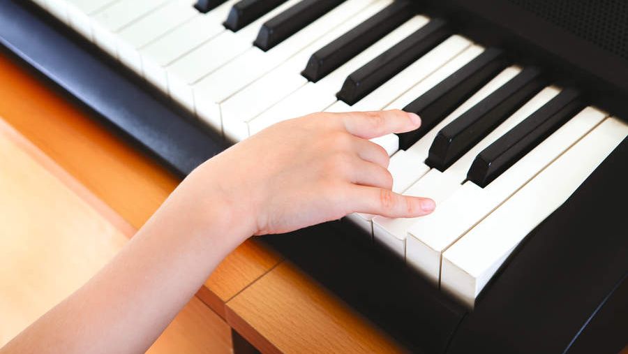 Child&#039;s hand on a beginner keyboard 