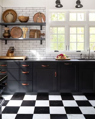 Chequered kitchen floor with metro tiling, dark cabinets with leather straps