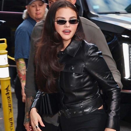 Selena gomez wears a leather jacket with sunglasses.