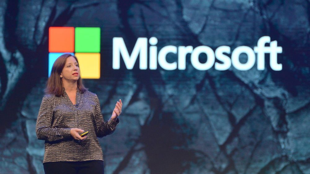 Clare Barclay, CEO of Microsoft UK, speaking on stage in front of a Microsoft banner