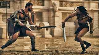 Viggo (Jóhannes Haukur Jóhannesson) and Kwame (Moe Hashim) decked out in gladiator gear as they face off in the arena in "Those About to Die"