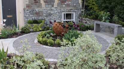 small front garden ideas: garden designed by Outerspace Creative Landscaping with round flowerbed and sculpture