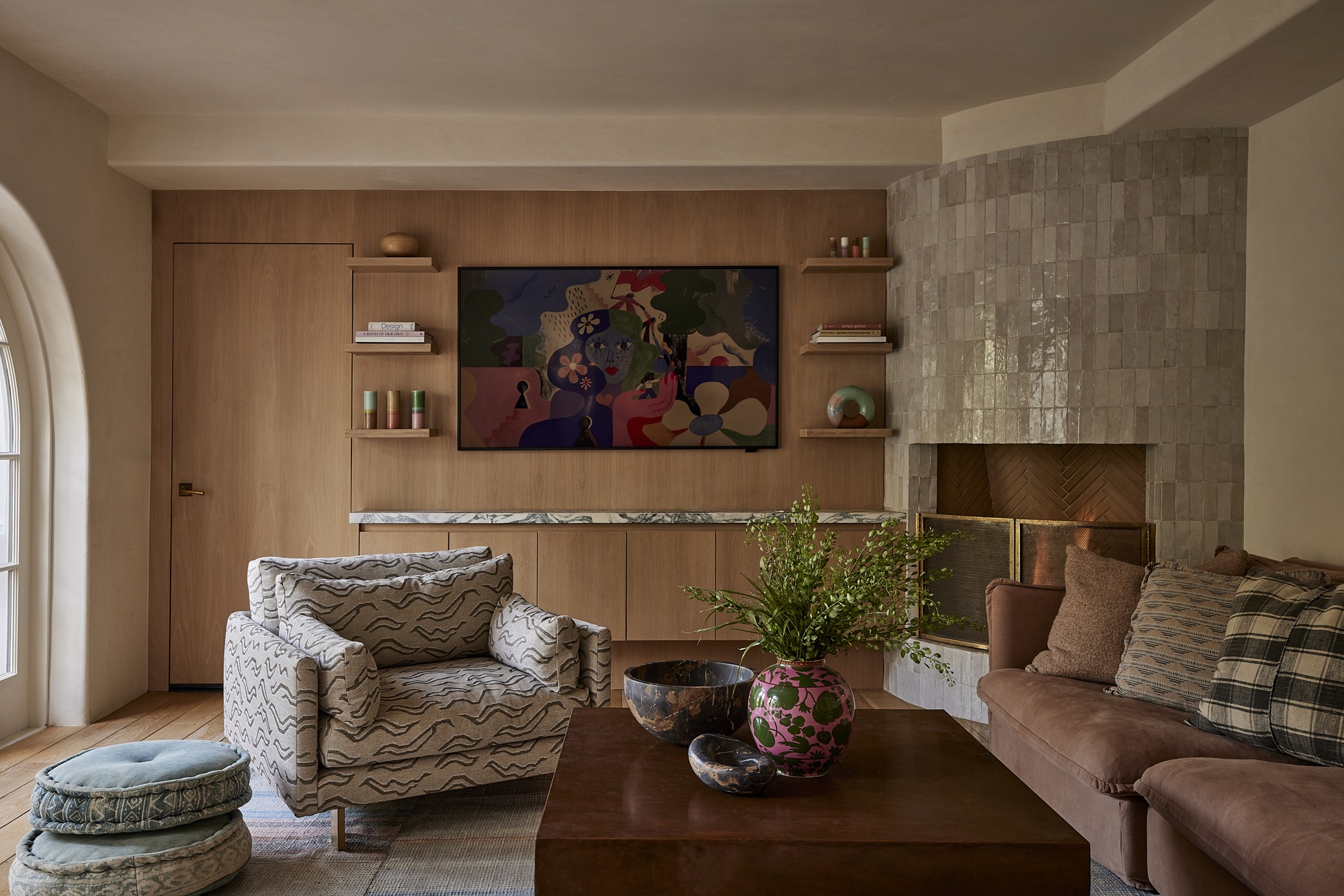 a room with a timber panel tv wall, tiled fireplaced and seating