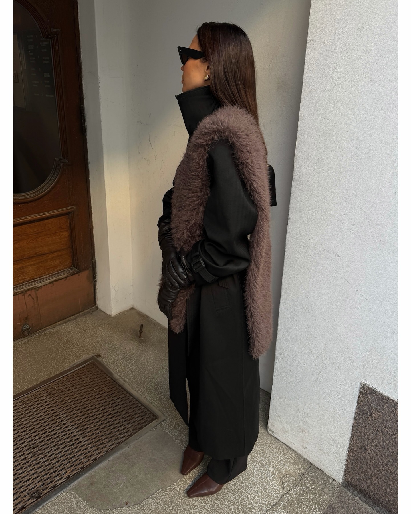 Woman wearing black jacket and brown fur stole.