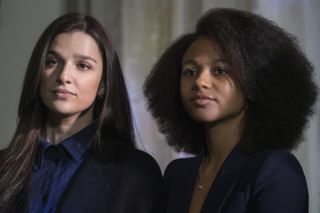 Yasmin (Marisa Abela) and Harper (Myha'la Herrold) stand side by side, both wearing dark suits, in a still from Industry's second season