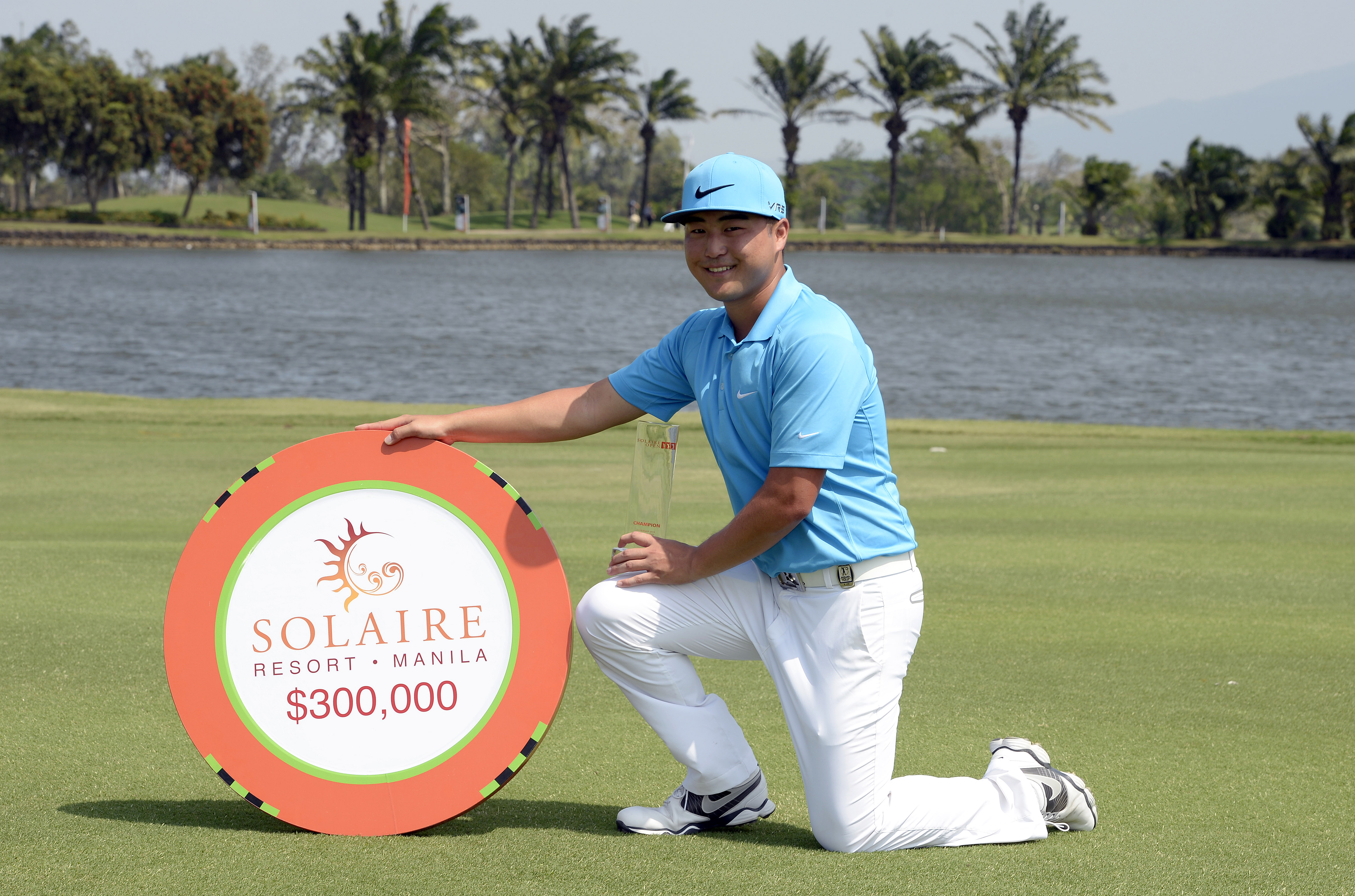 Richard T Lee posing with the Solaire Open trophy after winning in 2014
