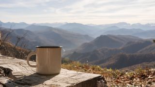 a white campfire enamel mug mockup with riverside view