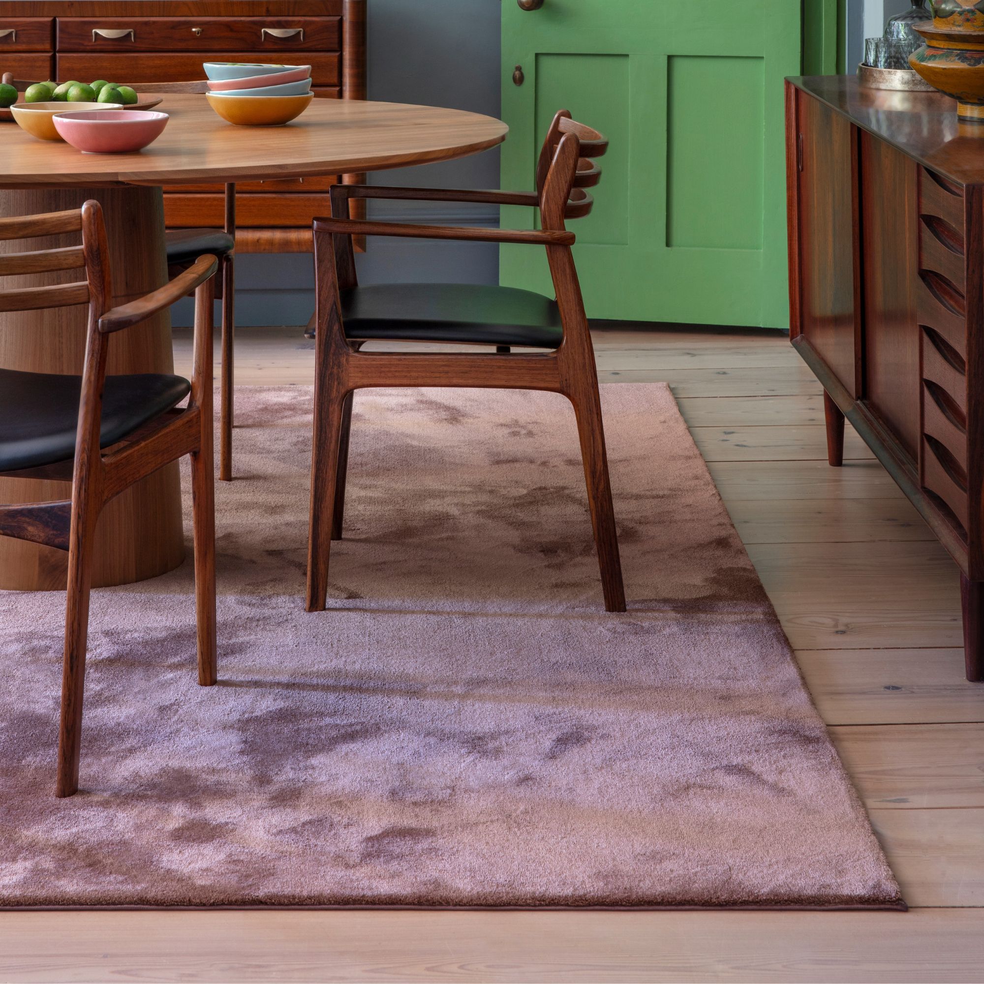 A mango wood dining table set on top of a plush purple carpet