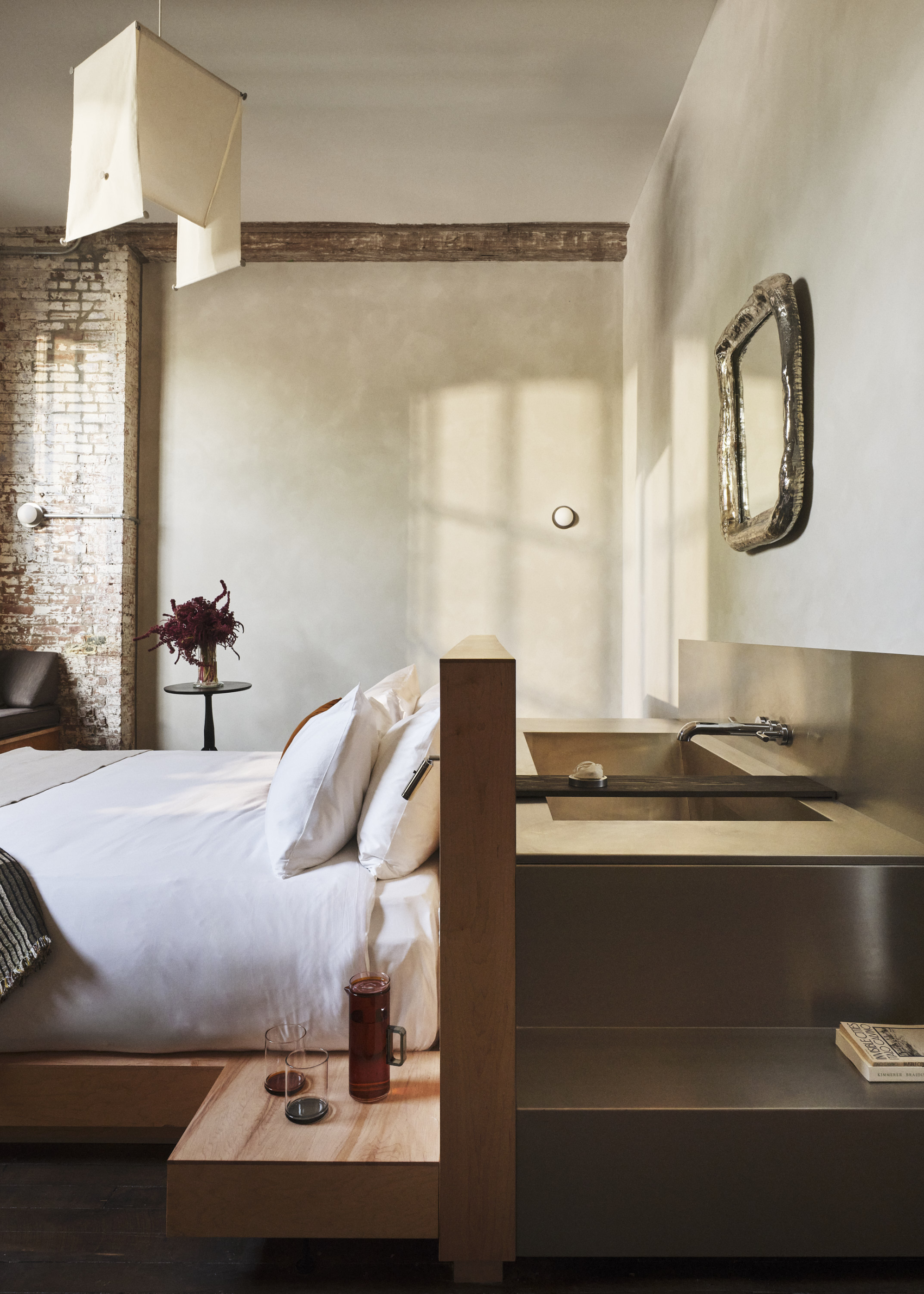 A stainless steel tub behind a wooden headboard in a hotel in Hudson, NY