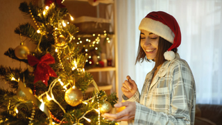 Smiling woman admiring a Christmas tree