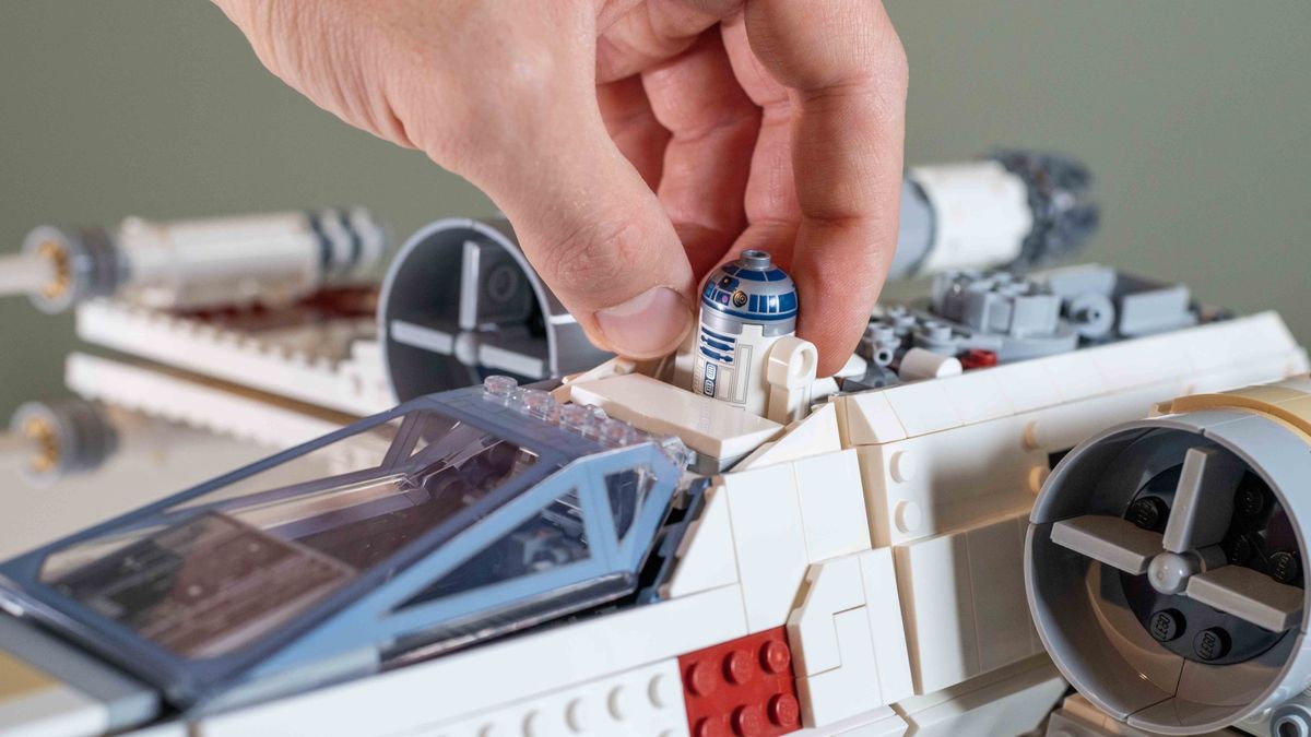 Lego UCS X-Wing Starfighter, hand placing R2D2 in the astromech socket