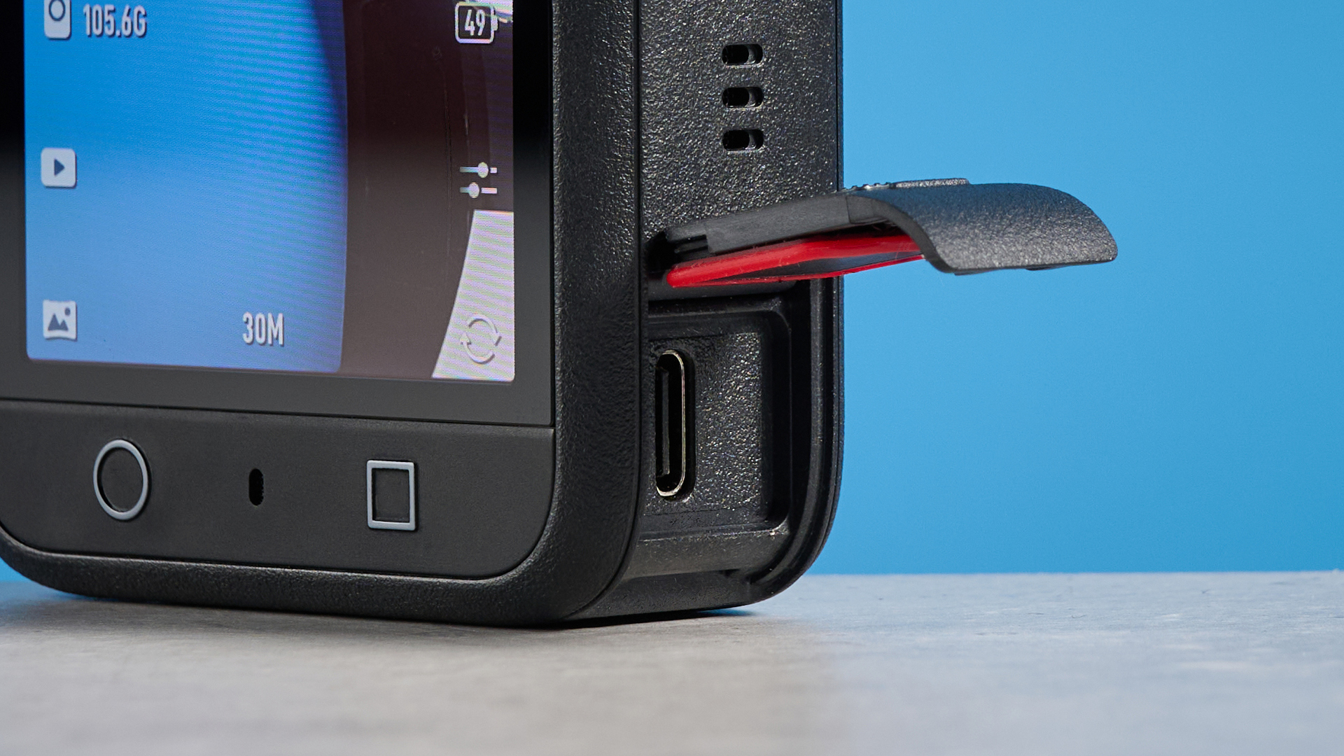 The DJI Osmo 360 USB hatch open against a blue background