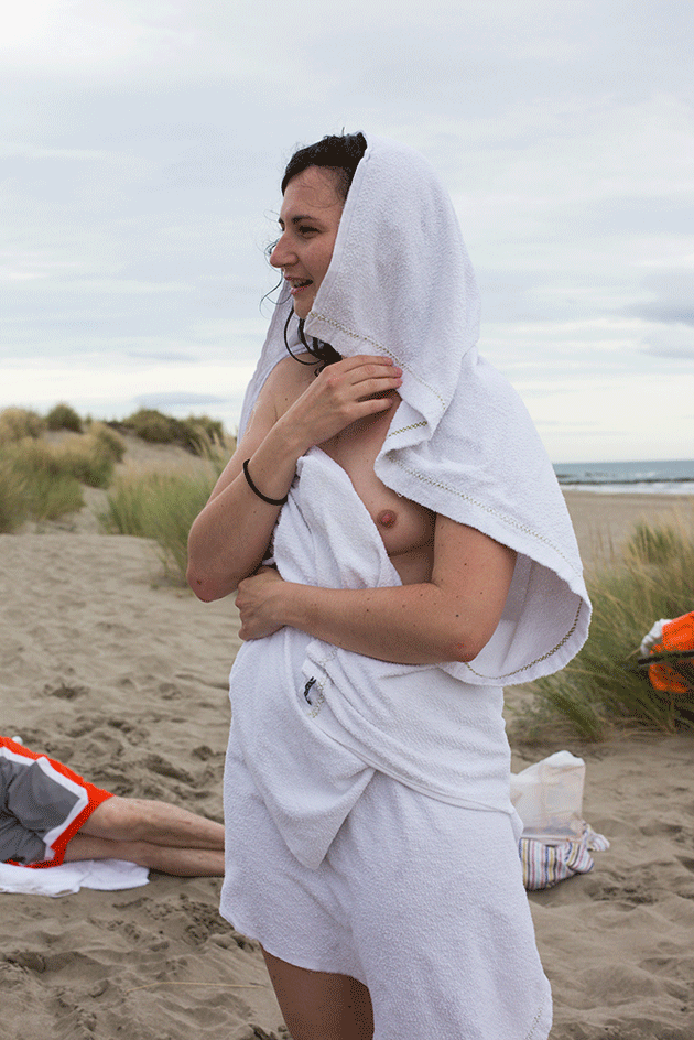 woman wrapped in white towel on beach