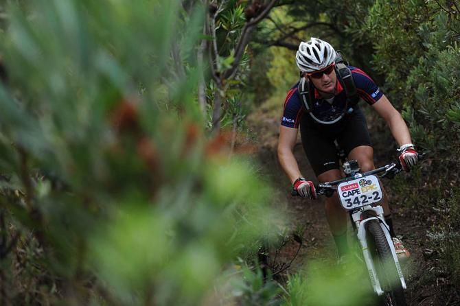 Gareth Edwards of Team eNCA rides down narrow singletrack