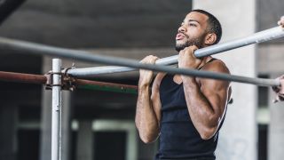 Man performs chin-up exercise in gym