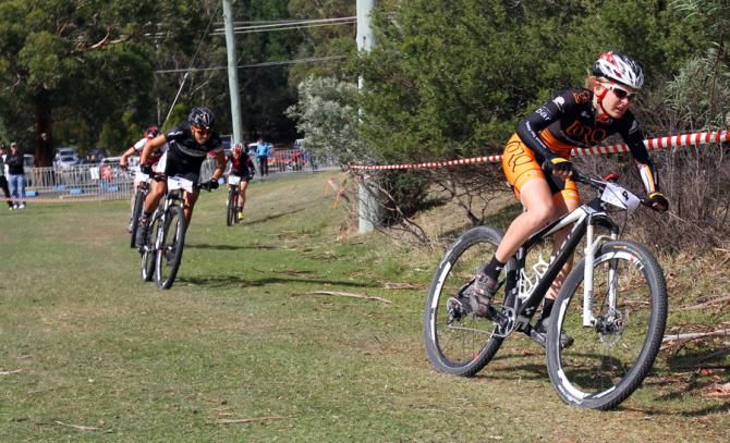 Emily Parkes leads in the final. She would crash on the next corner, then drop to fourth and move back up to third.