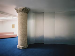 Ancient column inside minimalist art gallery