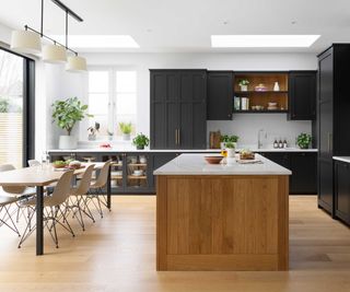 dark grey kitchen with wooden kitchen island and wooden flooring