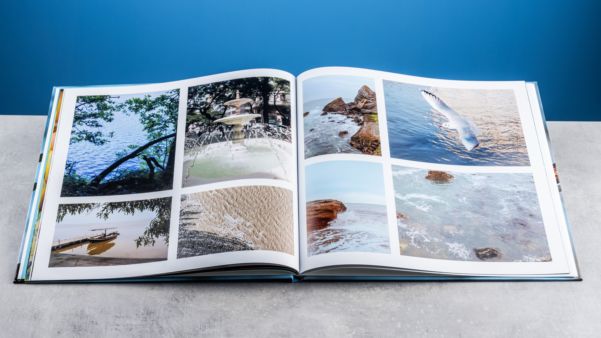 Vistaprint photo book pages photographed on a table in front of a blue background