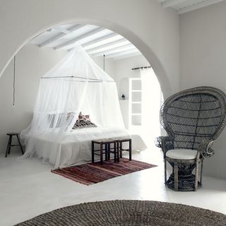 bedroom with double bed with net and chair