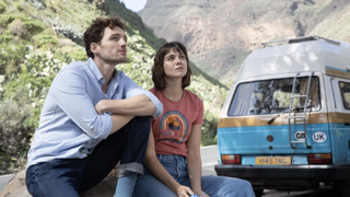 Dylan (Laurie Davidson) and Addie (Emma Appleton) sit together on a roadside, gazing into the distance