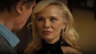 A slightly teary eyed Pamela Anderson looks up at Liam Neeson in The Naked Gun (2025). 