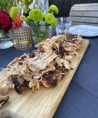 pulled pork on a chopping board on a garden table