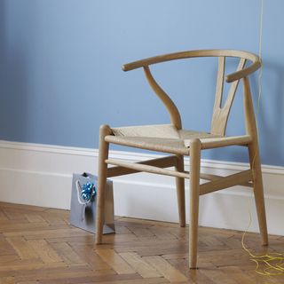wooden chair with blue wall and paper bag