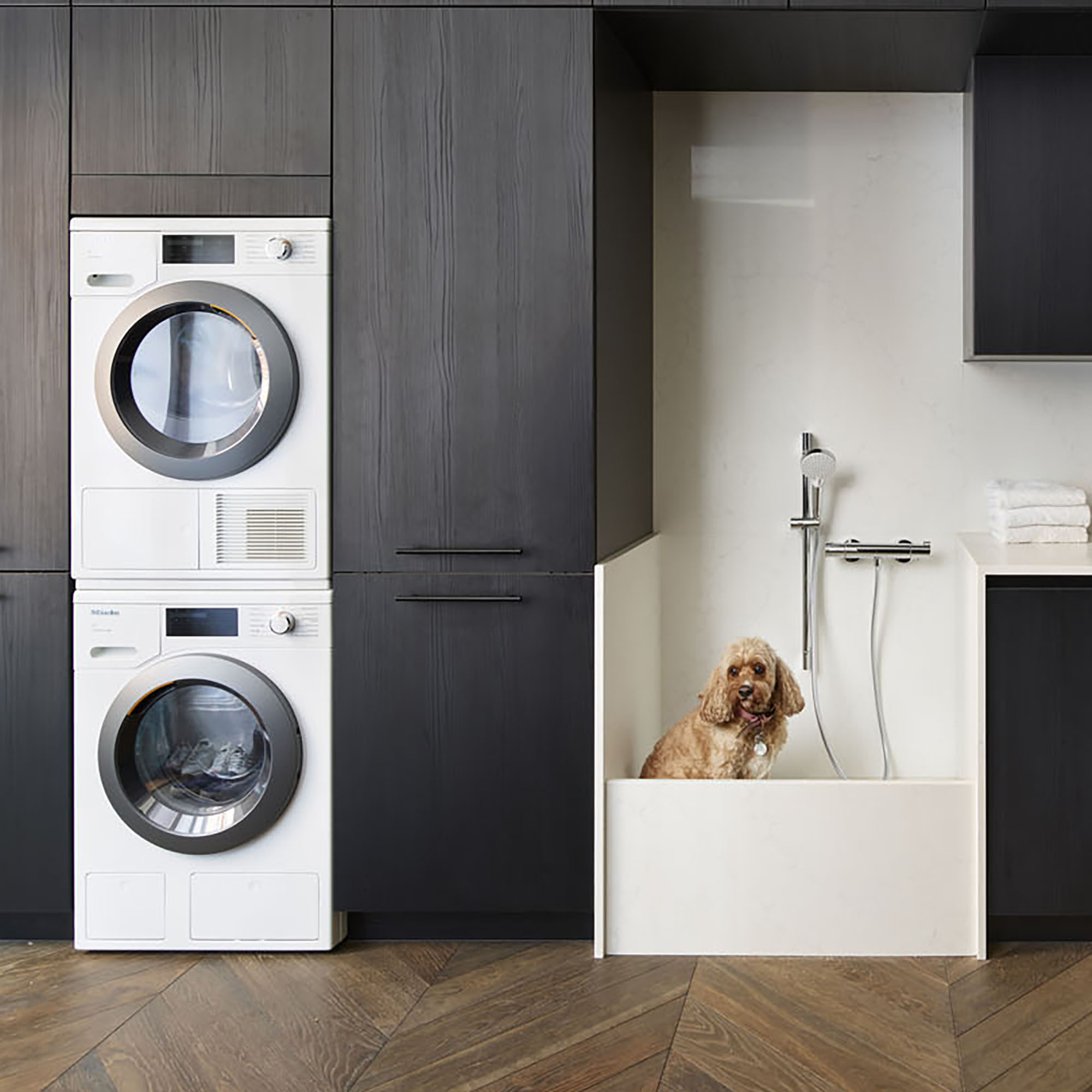 Utility room with navy units, stacked appliances and dog basin
