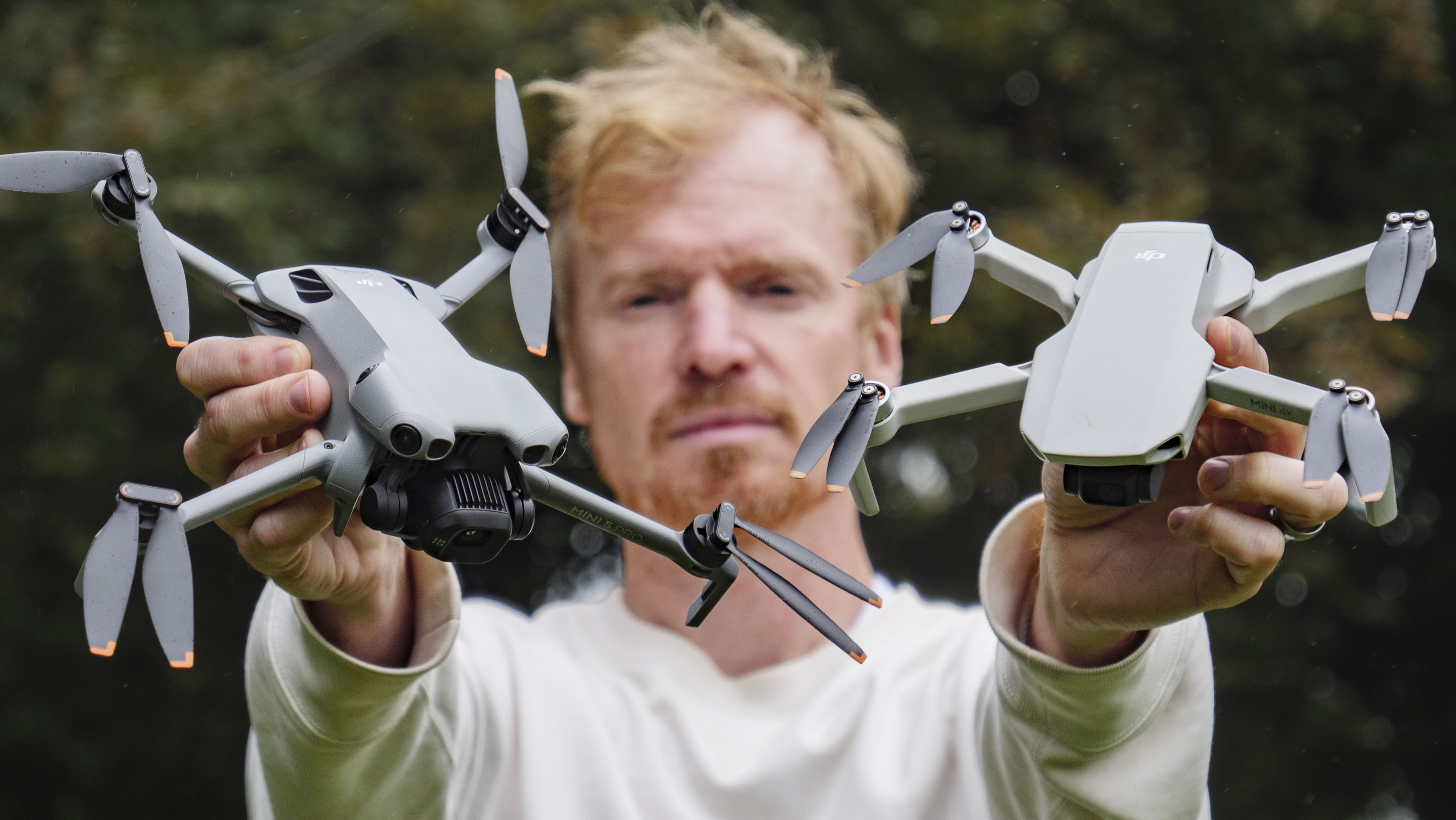 DJI Mini 5 Pro and DJI Mini 4K drones held by side by side