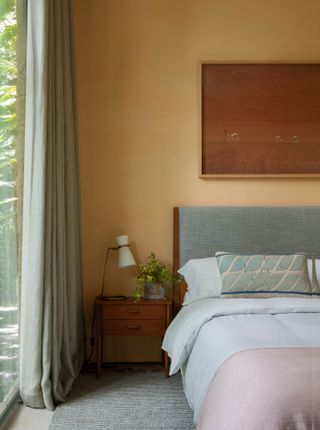 Bedroom with deep magnolia walls, grey bed and pink throw
