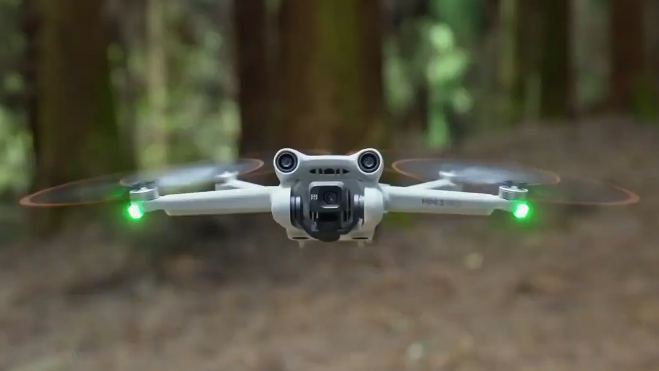 The DJI Mini 3 Pro drone in flight in a forest