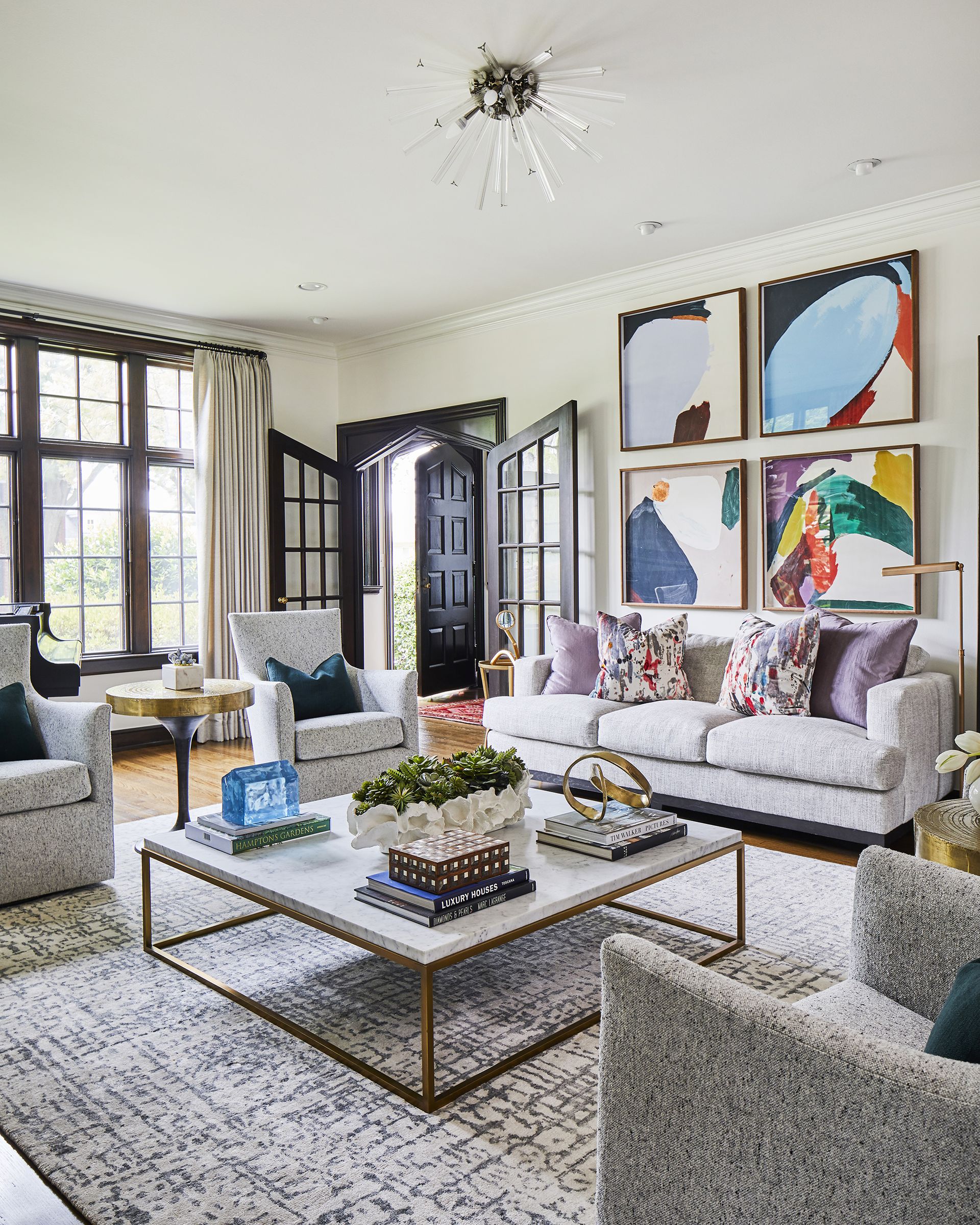 artwork in living room wall with four pieces of art on a bare wall