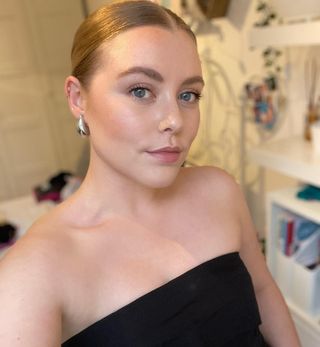 Florrie wears a black strapless top and silver stud earrings