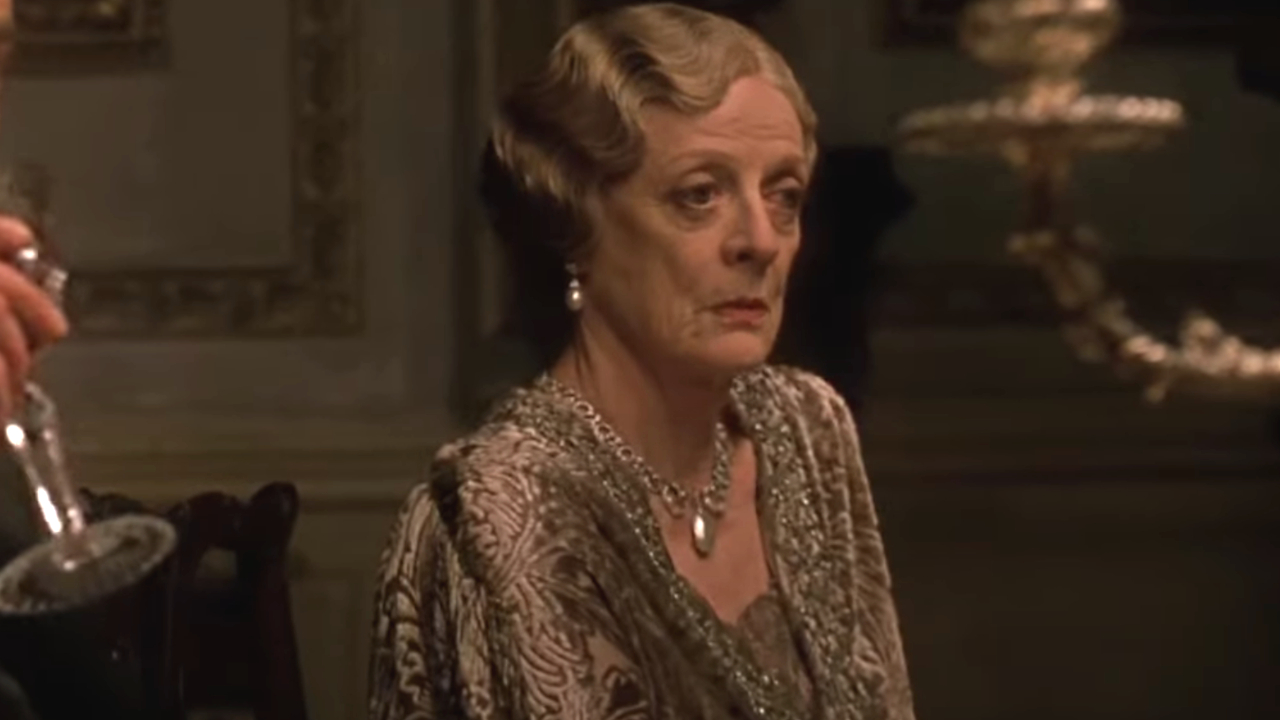 Maggie Smith sits with a non plussed look on her face at dinner in Gosford Park.