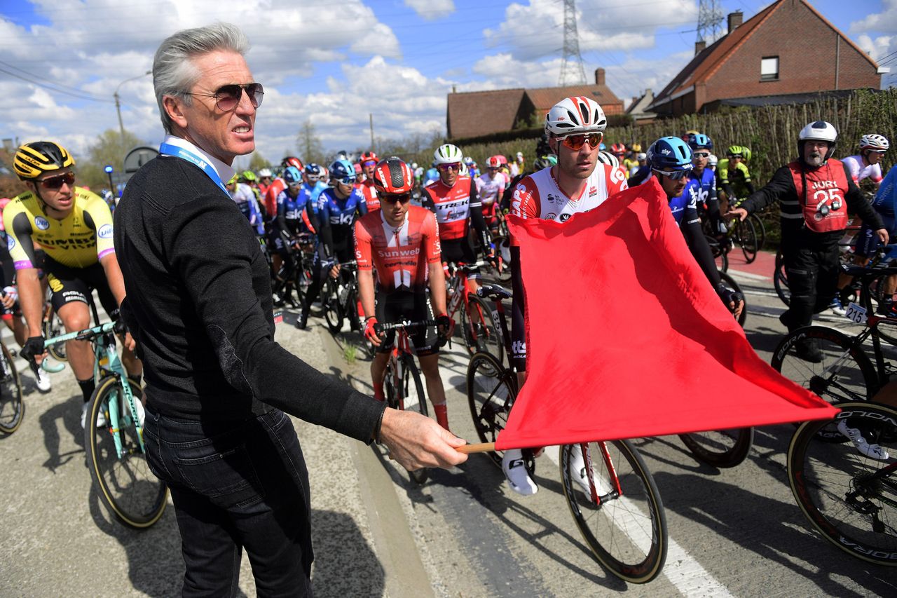 Scott Sunderland, the race director for Flanders Classics, stops the men's peloton