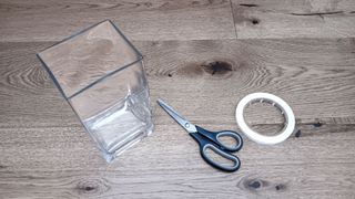 Glass vase with scissors and tape