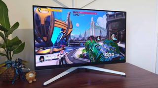 BenQ Mobiuz EX321UX gaming monitor with Overwatch 2 gameplay on screen featuring Pharah with jade gun skin