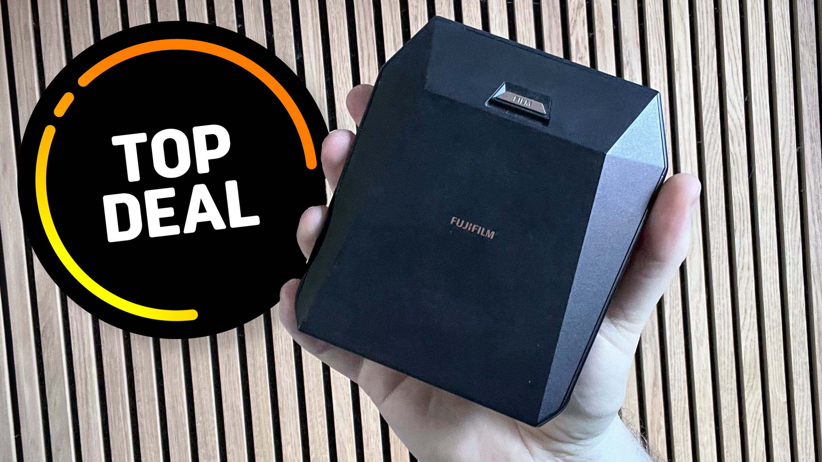 Instax Share SP-3 held in a man's hand against a wooden panel