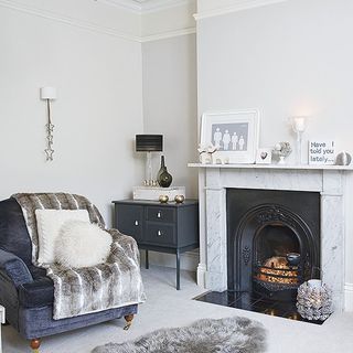 fireplace with whit e wall white flooring and sofa chair