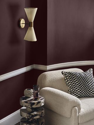 A living room with a cream sofa and purple walls